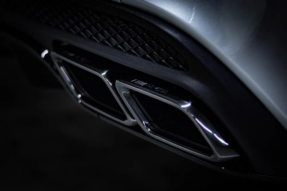Twin exhaust tips on a dark performance car